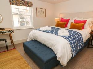 a bedroom with a large bed with a blue ottoman at 16 Arwenack Street in Falmouth