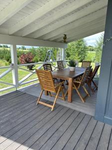una mesa de madera y sillas en un porche en Villa Vita, en Seimėnai