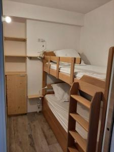 a small room with two bunk beds in it at Plein centre de station, au pied du tube in Valberg