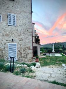 a stone building with a sunset in the background at The Loft By Birillo in Poggibonsi