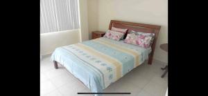 een slaapkamer met een bed met kussens erop bij Hermoso departamento a pasos de la playa! in Tonsupa