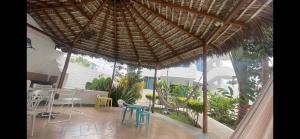 een patio met een rieten parasol en een tafel en stoelen bij Hermoso departamento a pasos de la playa! in Tonsupa