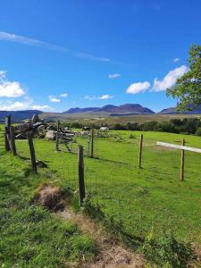 a fence in the middle of a green field at Cabin in Trawsfynydd