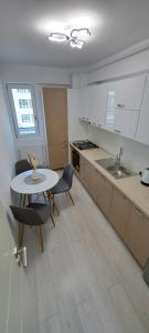 a kitchen with a table and chairs and a sink at Relax Home Apartment Q in Iaşi