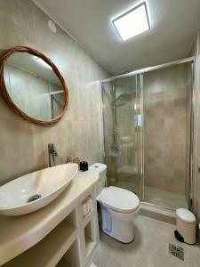 uma casa de banho com um WC, um lavatório e um chuveiro em Moma Apartment em Kythnos