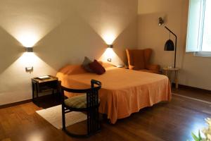 una camera con letto, sedia e luci di Tenuta I Gelsi a Benevento
