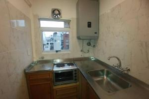 uma cozinha com um lavatório, um fogão e uma janela em Monoambiente Palermo temporario em Buenos Aires