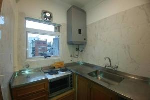 una pequeña cocina con fregadero y ventana en Monoambiente Palermo temporario en Buenos Aires