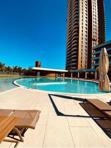 a swimming pool with two umbrellas next to tall buildings at Luxury residence with sea view in Konak