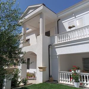 a white house with a porch and a balcony at Villa Kurti in Durrës