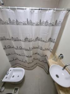 a bathroom with a sink and a shower curtain at Deparcasa in Yerba Buena