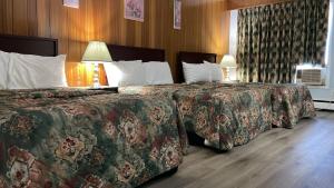 a hotel room with two beds and two lamps at Bel-Air Motel in Sault Ste. Marie