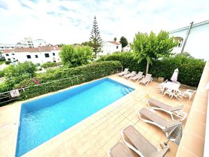 a swimming pool with chaise lounges and chairs at Villa Ana R9 in Santo Tomás