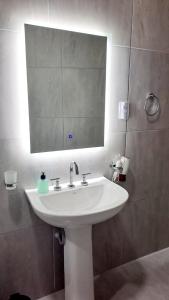 a bathroom with a white sink and a mirror at Casa Valle Viejo in San Fernando del Valle de Catamarca