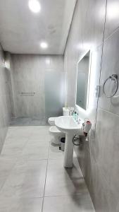 W białej łazience znajduje się umywalka i lustro. w obiekcie Casa Valle Viejo w mieście San Fernando del Valle de Catamarca