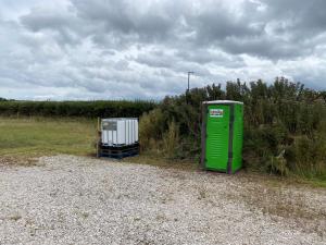 een groen object zit aan de zijkant van een veld bij Thurstaston Field in Thurstaston