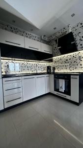 a large white kitchen with white cabinets and appliances at Apartament Mazurska Natura in Szczytno