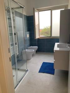 uma casa de banho com 2 WC e uma cabina de duche em vidro. em Appartamentino3 Collina Costa Dei Trabocchi em Villalfonsina