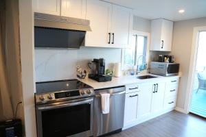 a kitchen with white cabinets and a stove top oven at Waterfront Paradise in Sooke
