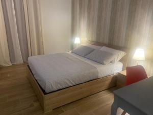 a bedroom with a bed with a desk and two lamps at Il Pavone in Taranto