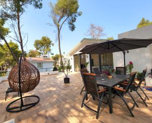 a patio with a table and chairs and an umbrella at PineTrees Penthouse @ the beach in Golem