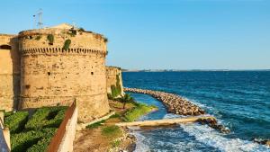 a castle next to the ocean with a water slide at Il Pavone in Taranto