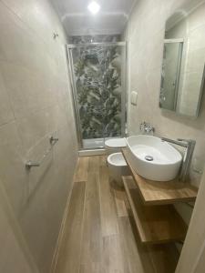 uma casa de banho com um lavatório, um WC e um espelho. em Il Pavone em Taranto