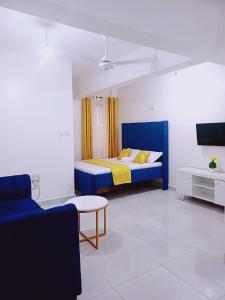 a bedroom with a blue bed and a couch at Medzam Homes Spacious Newly Furnished Studio in Mombasa