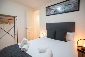 sypialnia z dużym białym łóżkiem z ręcznikami w obiekcie P2VIL1042 Modern & Cozy Apartment Poble Sec w Barcelonie