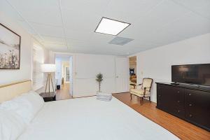 a bedroom with a large white bed and a living room at Jackson River Estate 3 dwellings on River w/ Pool sleeps 23 in Covington +103 photos