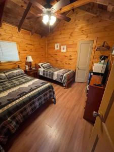 a bedroom with two beds in a log cabin at English Brook Cottages in Lake George