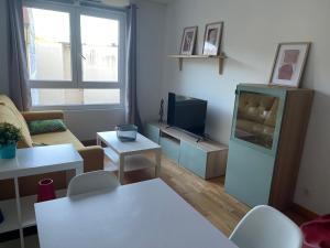 een woonkamer met een tv en een bank en een tafel bij Apartamento O Son in Cee