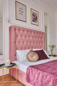 a pink bed with a large headboard in a bedroom at Lux Apartment in Mukacheve