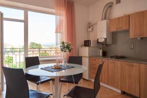 a kitchen with a table and chairs and a kitchen with a balcony at Lux Apartment in Mukacheve
