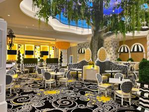 un vestíbulo con sillas, mesas y un árbol en Scarlet Pearl Casino Resort, en Biloxi