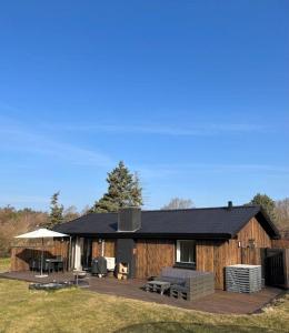 a log cabin with a deck and a patio at Cosy place with adoring sunny terrace in Vejby