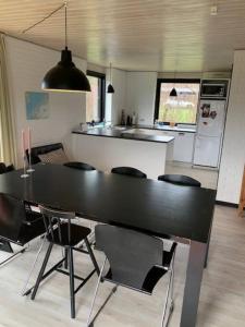 a kitchen with a large black table and chairs at Cosy place with adoring sunny terrace in Vejby
