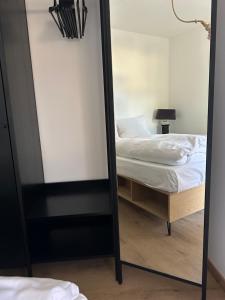 a mirror reflecting a bed in a bedroom at Seeapartment in Prien am Chiemsee