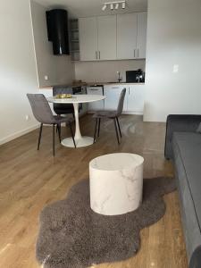 a living room with a couch and a table and chairs at Apartament Wiczlino Tęczowa in Gdynia