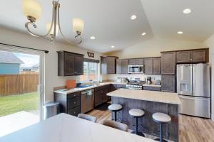 a kitchen with wooden cabinets and a kitchen island with bar stools at Bridger View Retreat in Belgrade