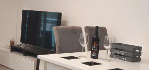 una mesa con dos copas de vino y un televisor en Beautiful apartment in the center, en Tarragona