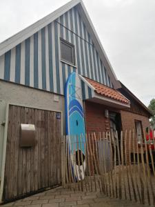 ein Gebäude mit einem Surfbrett auf der Seite in der Unterkunft Wellenbude in Otterndorf