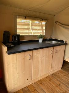 a kitchen in a tent with a sink in it at Glampingtent - Camping Botniahiem - Damwoude 