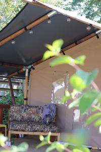 a tent with a couch in the back of it at Glampingtent - Camping Botniahiem - Damwoude-dichtbij Dokkum in Dantumawoude