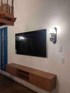 uma sala de estar com uma televisão de ecrã plano na parede em Valentino House piscina internet parking desayuno em Mendoza