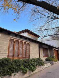 a building with brown shutters on the side of it at Valentino House piscina internet parking desayuno in Mendoza