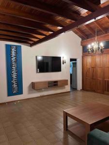 uma sala de estar com uma televisão de ecrã plano na parede em Valentino House piscina internet parking desayuno em Mendoza