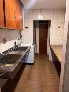 uma cozinha com um lavatório e uma máquina de lavar roupa em Valentino House piscina internet parking desayuno em Mendoza