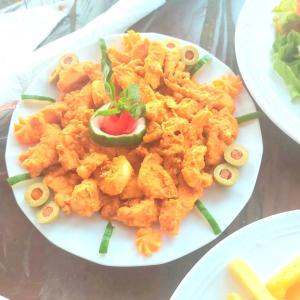 un plato de comida con camarones en una mesa en Blue Palm Resort Ghana, en Abia