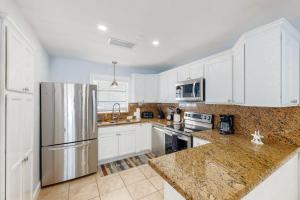 a kitchen with white cabinets and a stainless steel refrigerator at Sunny Bank in Marathon